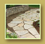 Gorgeous flagstone path beside stone wall and maroon astilbe